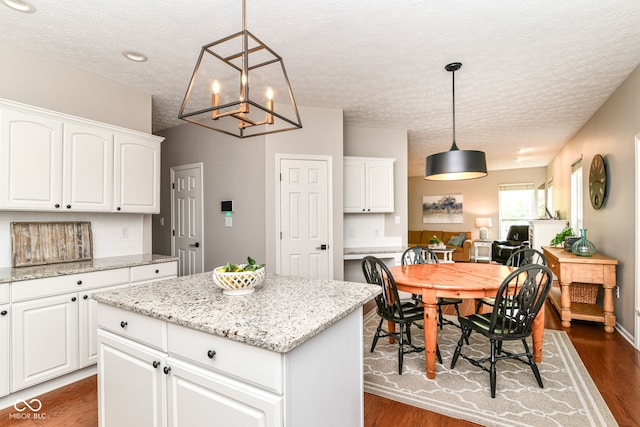 kitchen with backsplash, dark wood-style floors, and a textured ceiling