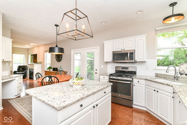 kitchen featuring a sink, appliances with stainless steel finishes, white cabinets, and a healthy amount of sunlight