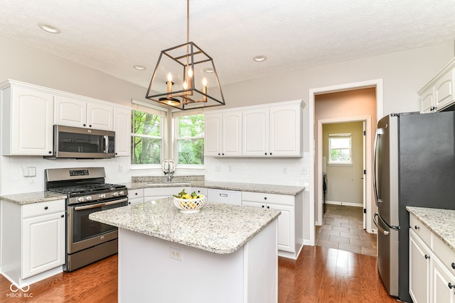 kitchen with decorative backsplash, a sink, white cabinets, and stainless steel appliances