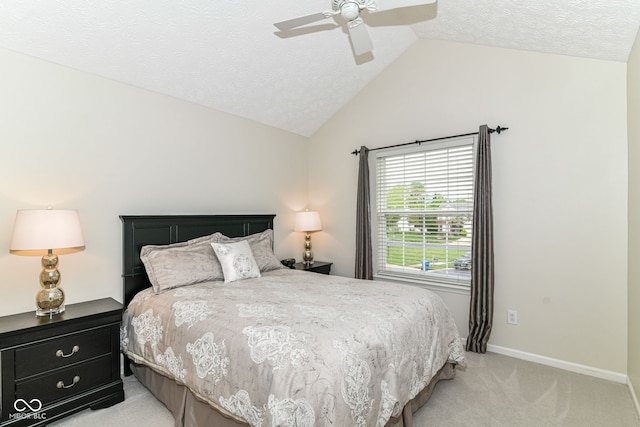bedroom featuring a ceiling fan, a textured ceiling, light colored carpet, vaulted ceiling, and baseboards