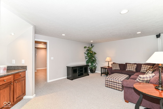 living room featuring recessed lighting, a textured ceiling, light colored carpet, and baseboards