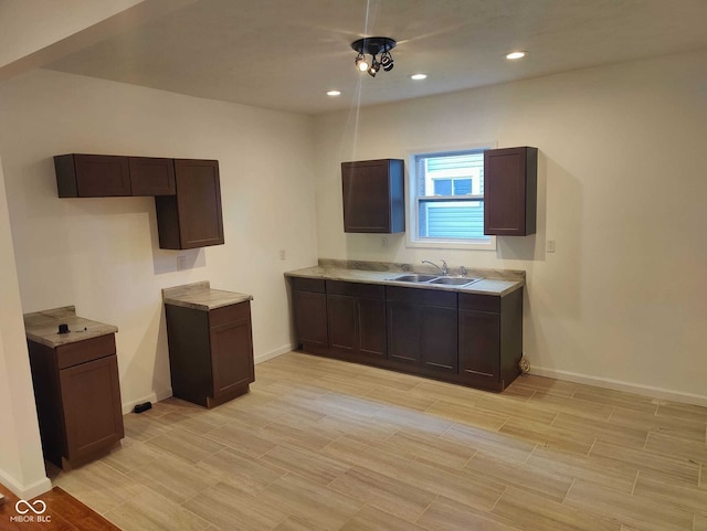 3629 Birchwood Ave, Indianapolis, IN 46205 - kitchen featuring a sink, light countertops, dark brown cabinetry, baseboards, and recessed lighting