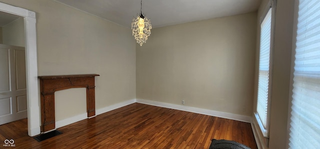 unfurnished dining area with a notable chandelier, visible vents, a wealth of natural light, and dark wood finished floors
