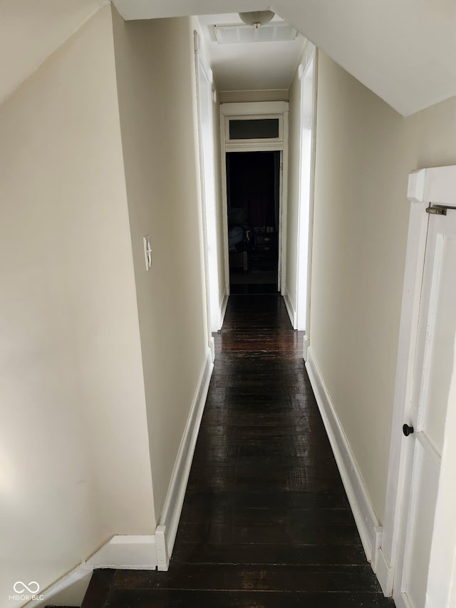 hall featuring baseboards and dark wood-style flooring