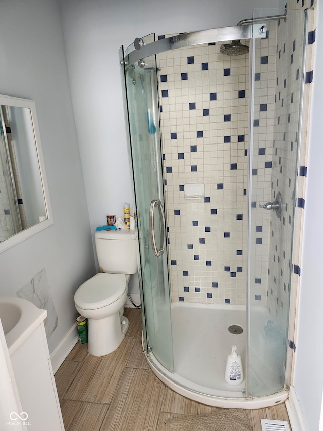 full bathroom with baseboards, a stall shower, toilet, and vanity