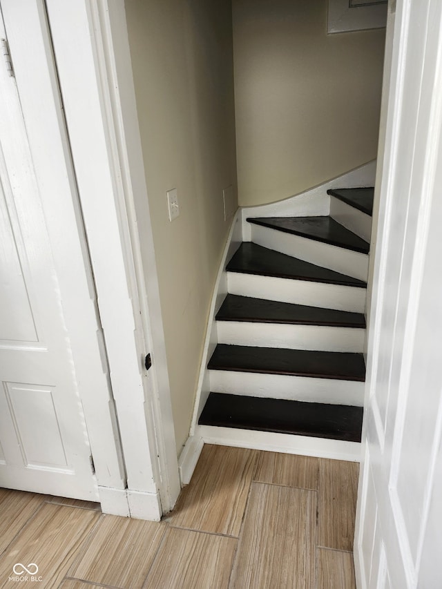 staircase with baseboards and wood finished floors