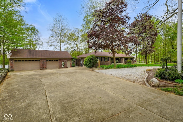 ranch-style house featuring a garage, concrete driveway, and brick siding