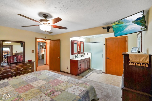 bedroom featuring a textured ceiling, visible vents, light carpet, and ensuite bathroom