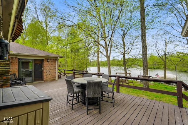 deck with a water view and outdoor dining space