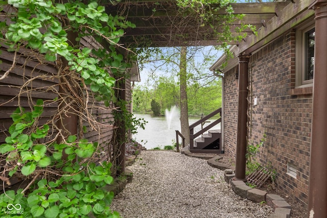 view of side of home featuring brick siding and a water view