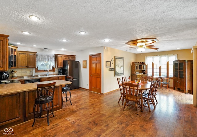 dining space with a ceiling fan, a textured ceiling, dark wood finished floors, baseboards, and recessed lighting