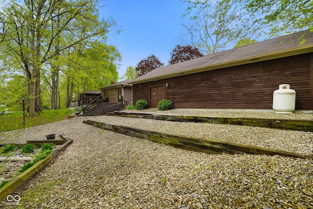 view of side of home with a wooden deck and a chimney