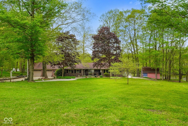 view of yard featuring an attached garage and driveway