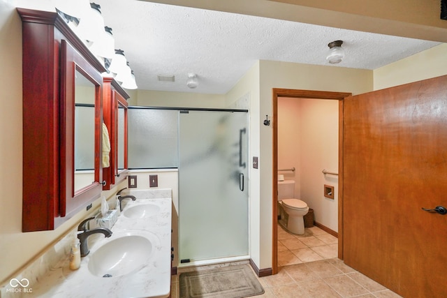 bathroom with a sink, tile patterned floors, a shower stall, and toilet