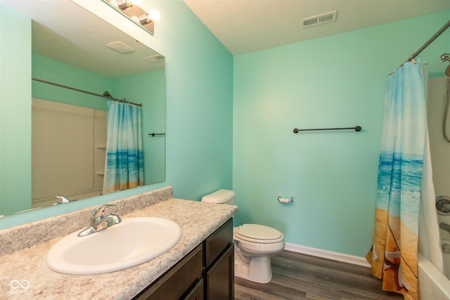 bathroom featuring wood finished floors, toilet, vanity, baseboards, and shower / tub combo with curtain