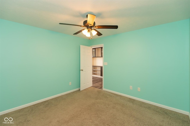 empty room with ceiling fan, baseboards, and carpet flooring