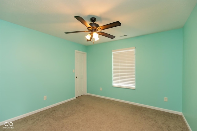 carpeted spare room featuring ceiling fan and baseboards