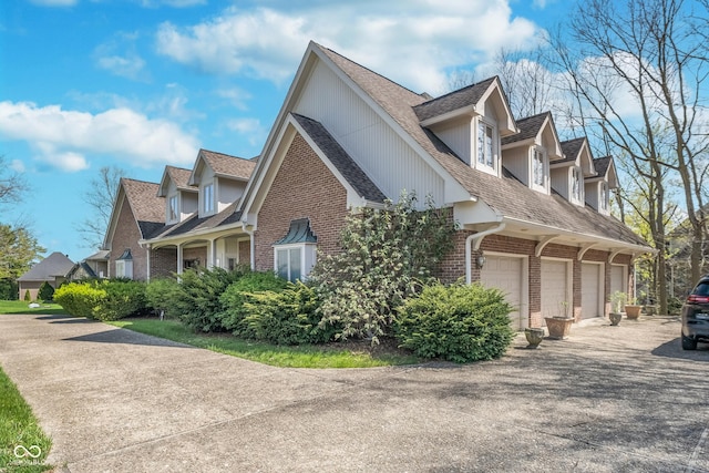 view of property exterior featuring brick siding, a shingled roof, a garage, and concrete driveway
