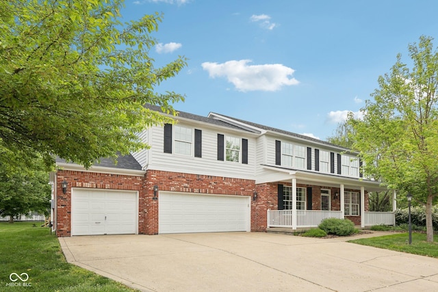 traditional home with a porch, an attached garage, brick siding, driveway, and a front yard