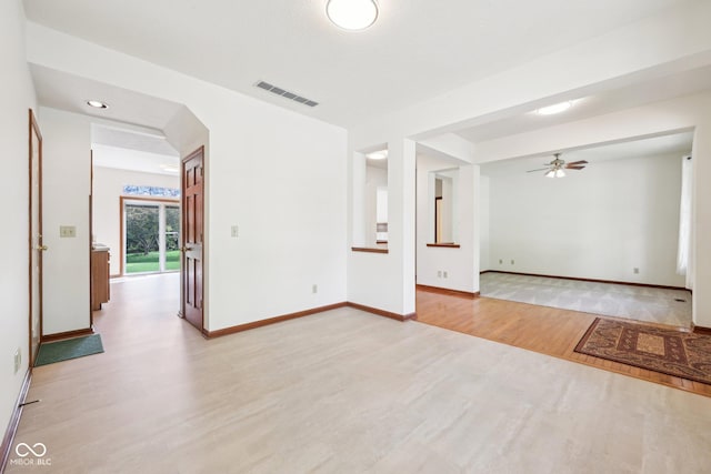 spare room with light wood-style floors, ceiling fan, and baseboards