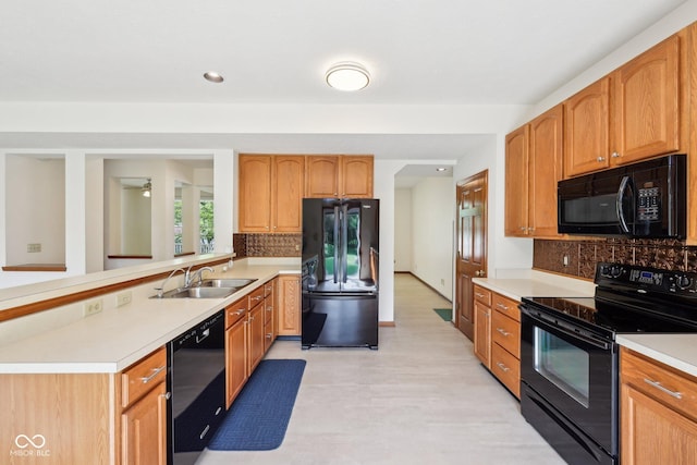 kitchen with black appliances, a sink, light countertops, tasteful backsplash, and recessed lighting