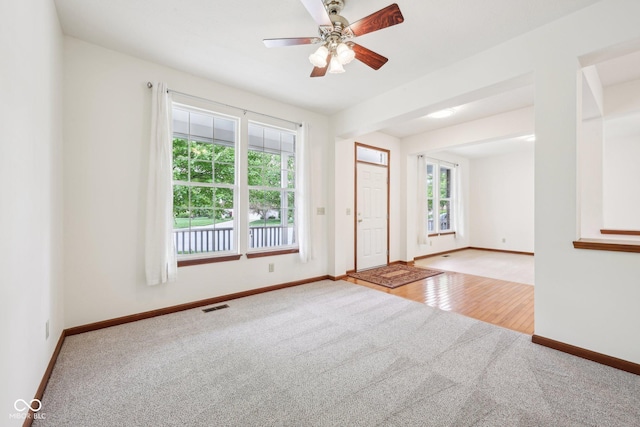 unfurnished room with carpet floors, baseboards, and a ceiling fan