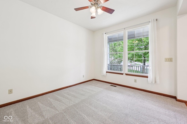 empty room featuring carpet flooring, baseboards, and a ceiling fan