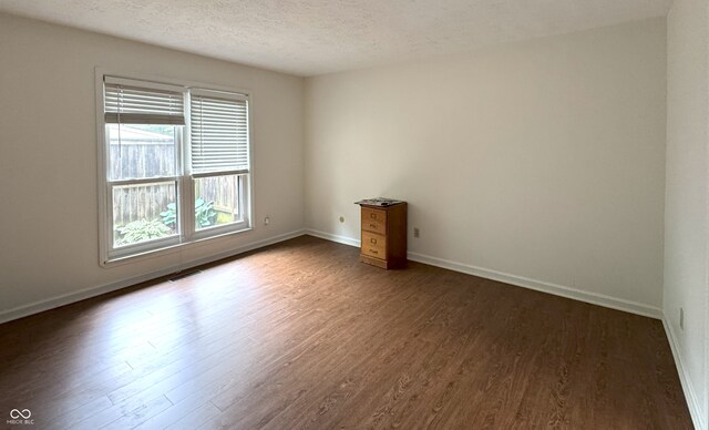 4212 Foxglove Trce, Indianapolis, IN 46237 - spare room with dark wood-type flooring, a textured ceiling, and baseboards