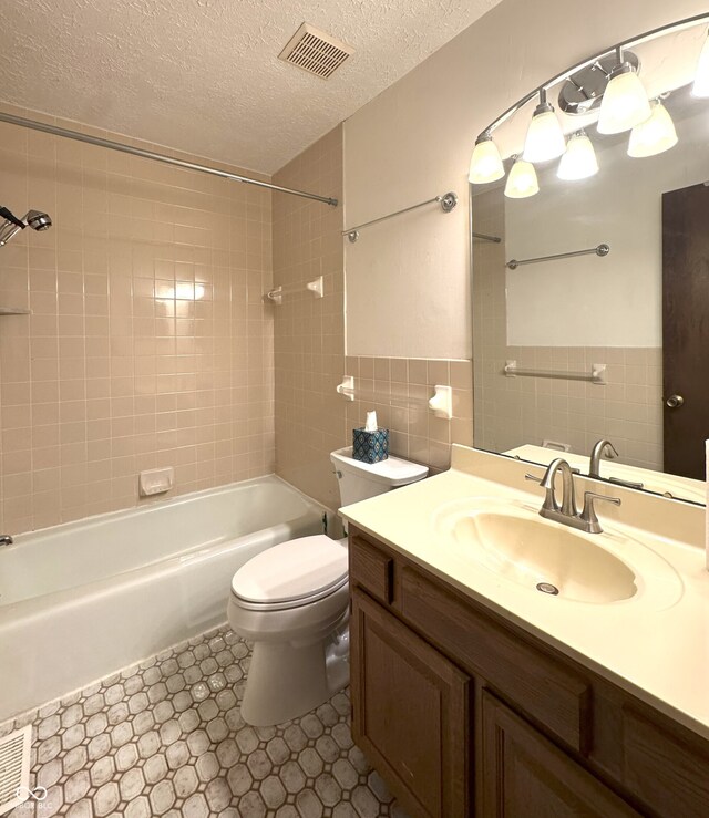 4212 Foxglove Trce, Indianapolis, IN 46237 - bathroom featuring tile walls, tub / shower combination, toilet, vanity, and a textured ceiling