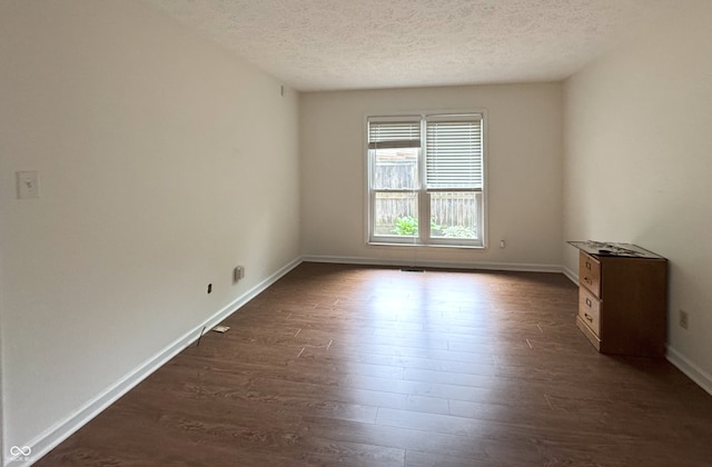 4212 Foxglove Trce, Indianapolis, IN 46237 - spare room featuring a textured ceiling, dark wood-type flooring, and baseboards