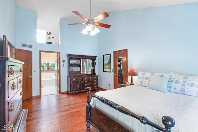 bedroom featuring high vaulted ceiling, hardwood / wood-style floors, a ceiling fan, baseboards, and visible vents