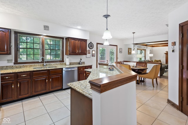 kitchen featuring a sink, light tile patterned floors, stainless steel dishwasher, and a textured ceiling