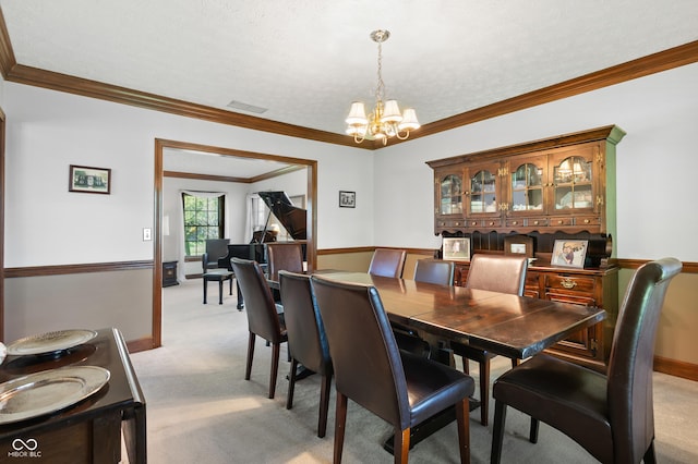 dining area with visible vents, crown molding, a notable chandelier, and light colored carpet