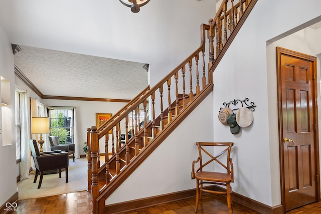 staircase with a textured ceiling, baseboards, and ornamental molding