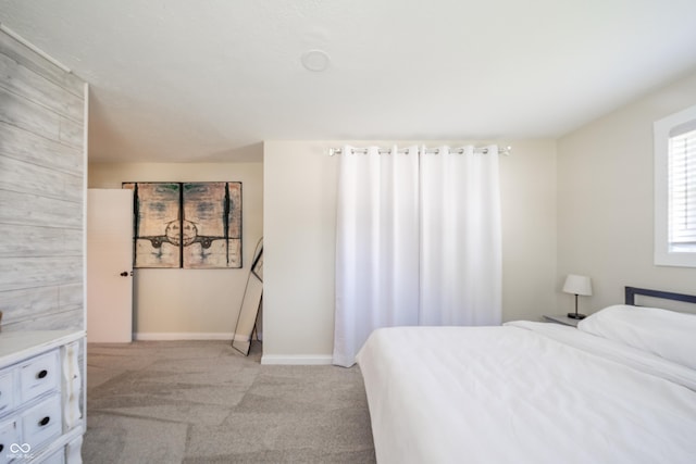 bedroom with baseboards and light carpet
