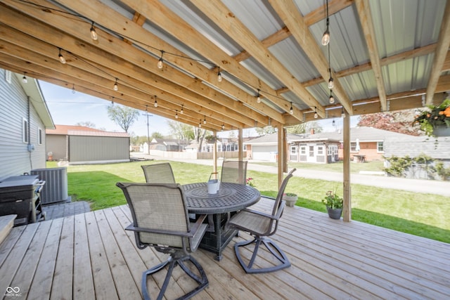 wooden deck featuring a lawn, outdoor dining area, central AC, and a residential view