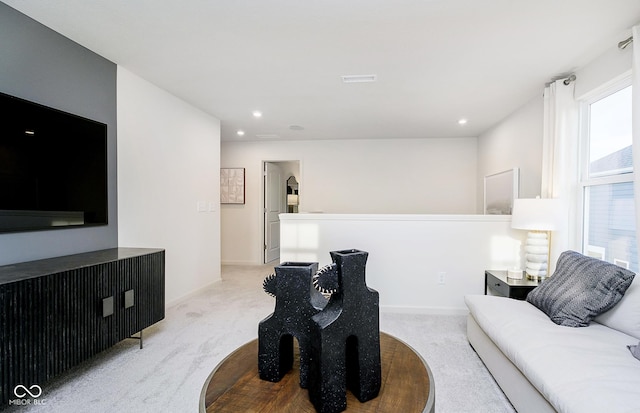 carpeted living area featuring baseboards, visible vents, and recessed lighting