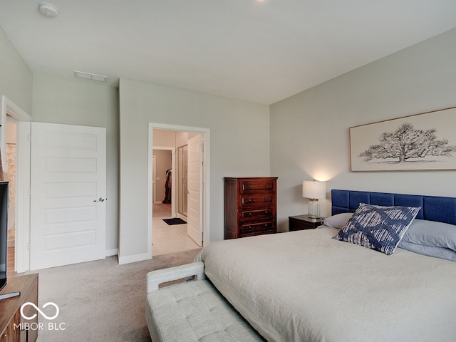 carpeted bedroom featuring connected bathroom, baseboards, and visible vents