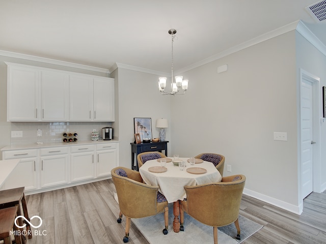 dining area with an inviting chandelier, visible vents, crown molding, baseboards, and light wood-style floors