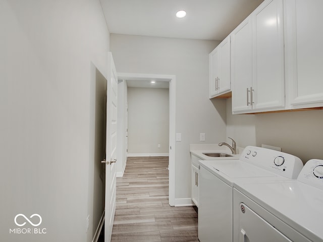 laundry area featuring recessed lighting, light wood-style flooring, separate washer and dryer, a sink, and cabinet space