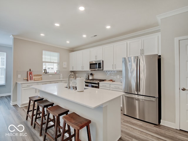 kitchen with a sink, appliances with stainless steel finishes, ornamental molding, and decorative backsplash
