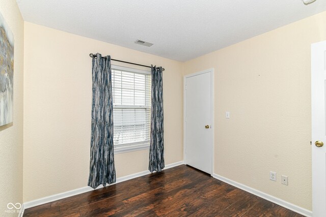 spare room with wood finished floors and baseboards
