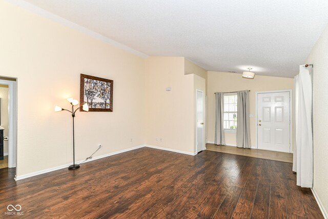 entrance foyer featuring dark wood finished floors, vaulted ceiling, and baseboards