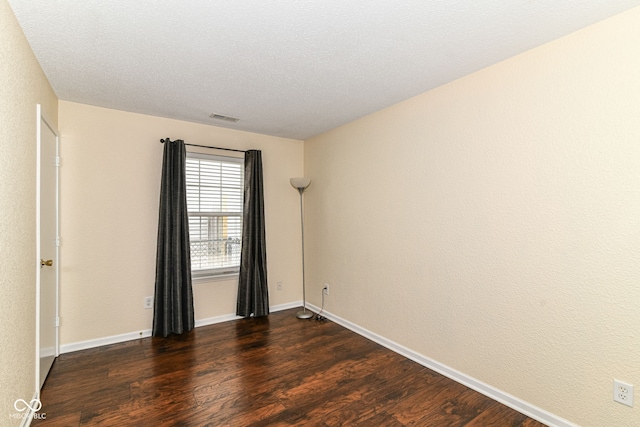 empty room with dark wood finished floors and baseboards