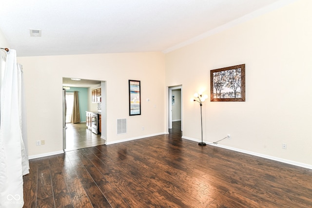 unfurnished room with vaulted ceiling, wood finished floors, and baseboards