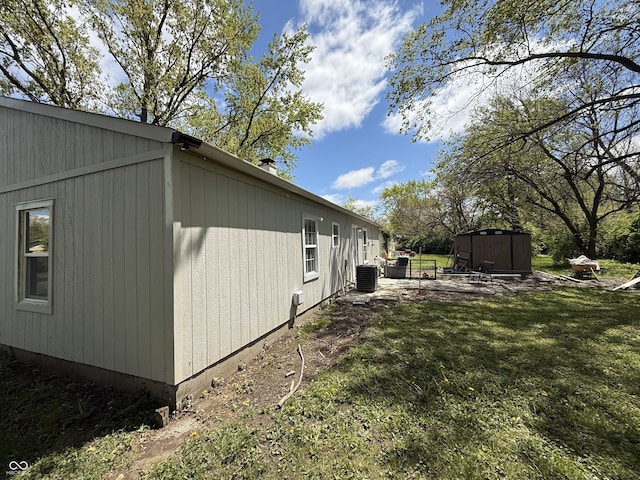 view of property exterior featuring central air condition unit, an outdoor structure, and a storage unit