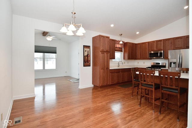 1623 W Stoneybrook Ln, Crawfordsville, IN 47933 - kitchen featuring appliances with stainless steel finishes, vaulted ceiling, light countertops, light wood finished floors, and decorative light fixtures