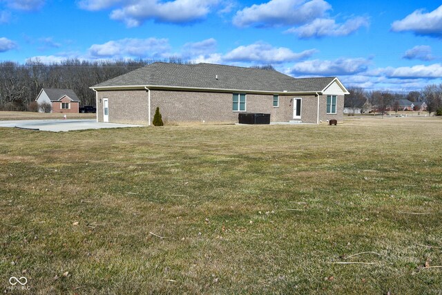 1623 W Stoneybrook Ln, Crawfordsville, IN 47933 - rear view of house with a yard, brick siding, and cooling unit