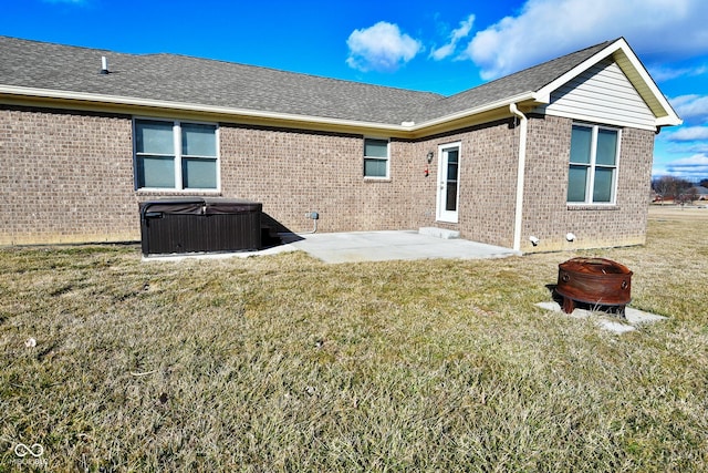 1623 W Stoneybrook Ln, Crawfordsville, IN 47933 - back of house with a hot tub, a fire pit, brick siding, a patio, and a yard
