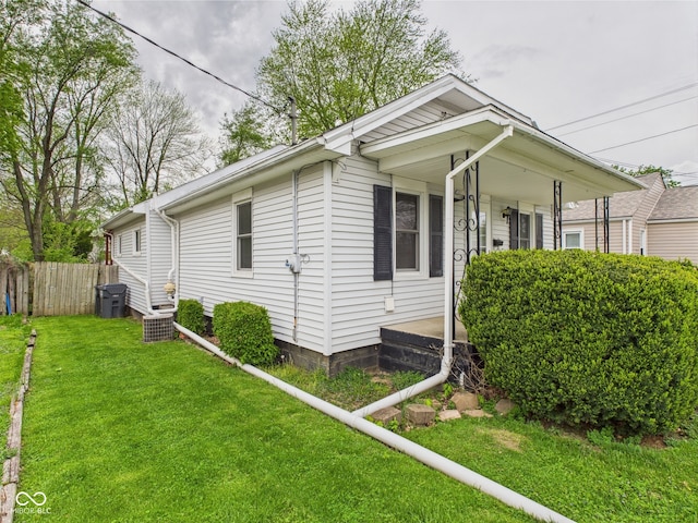 view of home's exterior with a lawn, central air condition unit, a porch, and fence